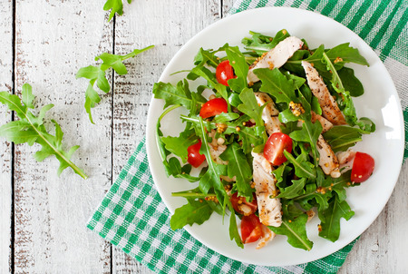 Fresh salad with chicken breast arugula and tomatoの写真素材