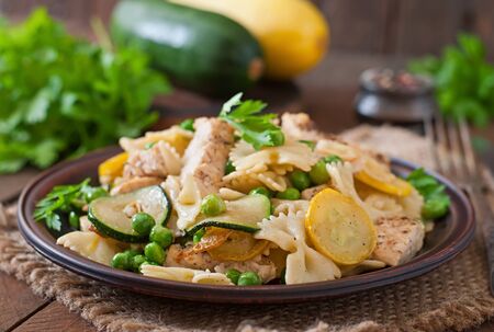 Pasta with zucchini, chicken and green peasの写真素材