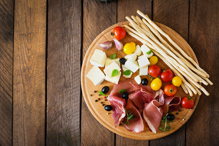 Meat appetizer on a plate on old wooden backgroundの写真素材