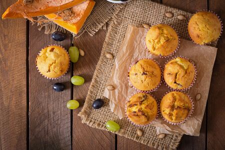 Appetizing and ruddy muffins with pumpkin and grapes. Top viewの写真素材