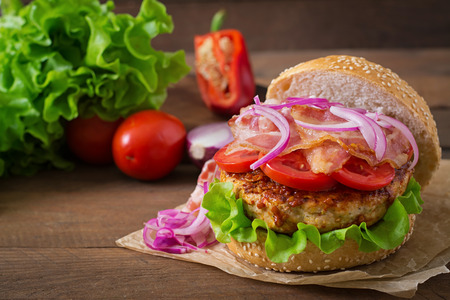 Big sandwich - hamburger burger with beef, red onion, tomato and fried bacon.の写真素材