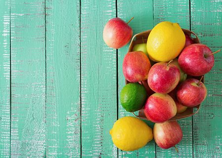 Ripe fruits apples, lemons and limes on a bright wooden background. Top viewの写真素材