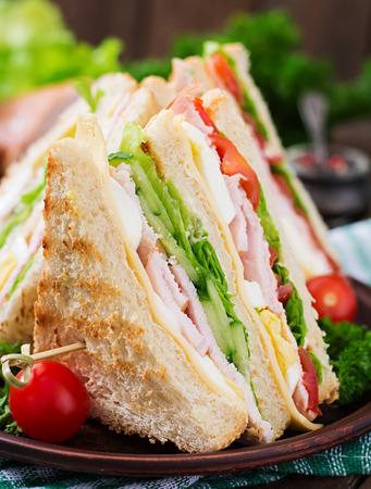 Club sandwich with cheese, cucumber, tomato, ham and eggs.の写真素材
