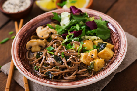 Miso and soba noodle soup with roasted tofu and mushroomsの写真素材