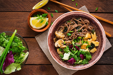 Miso and soba noodle soup with roasted tofu and mushrooms. Top view