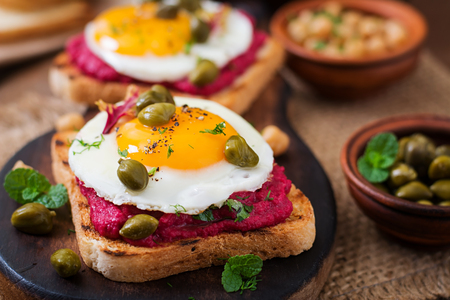 Diet sandwiches with beet root hummus, capers and eggの写真素材