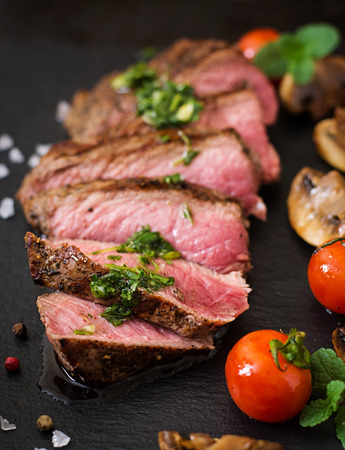 Juicy steak medium rare beef with spices and grilled vegetables.の写真素材