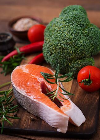 Raw steak salmon and vegetables for cooking on wooden background in a rustic style. Dietary menu. Proper nutrition.の写真素材