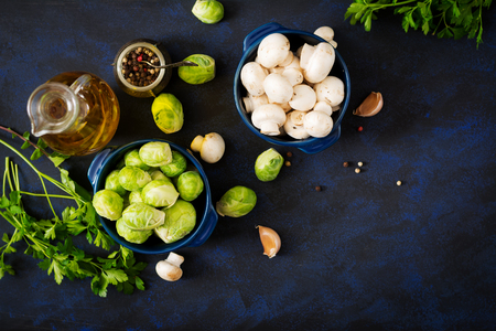 Dietary menu. Ingredients: Vegetables - Brussels sprouts, mushrooms, leeks and herbs on a dark background. Top view. Vegetables menu.の写真素材