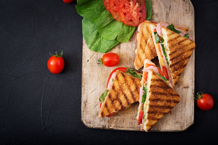 Club sandwich panini with ham, tomato, cheese and basil. Flat lay. Top viewの写真素材