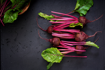 Young beetroot with a tops on a dark background. Flat lay. Top view.の写真素材