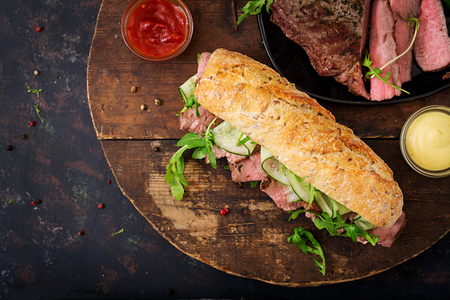 Sandwich of whole wheat bread with roast beef, cucumber and arugula. Top view. Flat lay.の写真素材