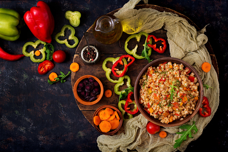 Vegetarian crumbly pearl barley porridge with vegetables  in a dark background. Flat lay. Top viewの写真素材