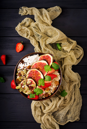 Delicious and healthy oatmeal with figs, seeds, strawberry and yogurt. Healthy breakfast. Fitness food. Proper nutrition.の写真素材