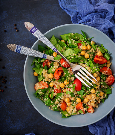 Dietary menu. Healthy vegan salad of fresh vegetables - tomatoes, chickpeas, spinach and quinoa in a bowl.の写真素材