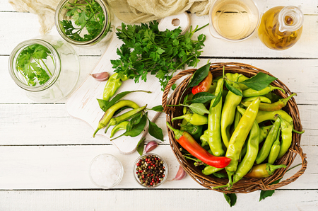 Green chili peppers in a basket on a white background. Preparation for pickling. Flat lay. Top viewの写真素材