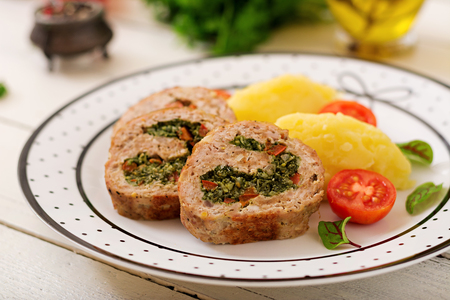 Roll of turkey minced meat with spinach and red sweet pepper with garnish of mashed potatoesの写真素材