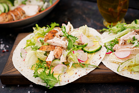 Healthy mexican tacos with baked chicken breast, cucumber, radish and lettuce.の写真素材