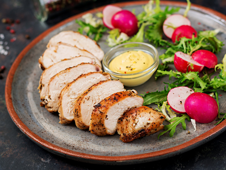 Baked chicken breast and fresh vegetables on the plate on a dark background. Proper nutrition. Dietary menu.の写真素材
