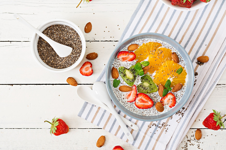 Detox and healthy superfoods breakfast in bowl. Vegan almond milk chia seeds pudding with strawberries, orange and  kiwi. Top view. Flat layの写真素材
