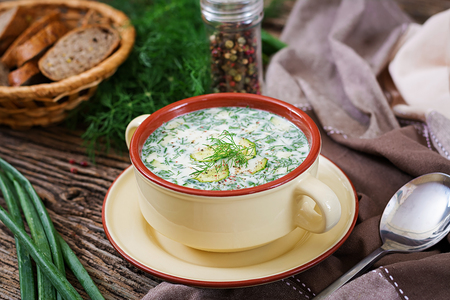 Summer yogurt cold soup with egg, cucumber, and dill on wooden table. Okroshka. Russian foodの写真素材
