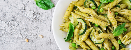 Penne pasta with  pesto sauce, zucchini, green peas and basil. Italian food. Top view. Flat lay. Bannerの写真素材