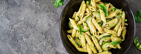 Penne pasta with  pesto sauce, zucchini, green peas and basil. Italian food. Top view. Flat lay. Bannerの写真素材