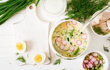 Ingredients for cooking summer yogurt cold soup with egg, cucumber, chicken and dill on wooden table. Okroshka. Russian food. Top view. Flat lay. Mockupの写真素材