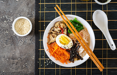 Diet vegetarian bowl of noodle soup of shiitake mushrooms, carrot and boiled eggs.  Japanese food. Top view. Flat layの写真素材