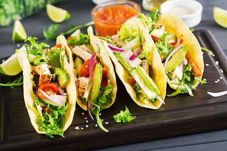 Mexican tacos with chicken meat, avocado, tomato, cucumber and red onion. Healthy tortilla. Wrap food. Tacoの写真素材