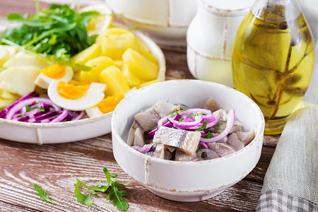 Marinated herring in bowl with onions. Scandinavian food.の写真素材