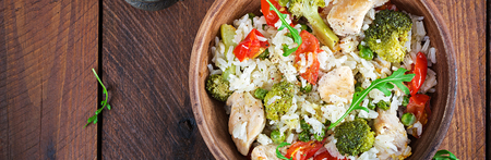 Delicious chicken, broccoli, green peas, tomato stir fry with rice. Asian cuisine. Healthy food. Banner. Top viewの写真素材