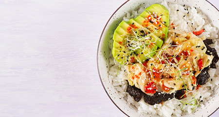 Vegan salad  with rice, pickled kimchi cabbage, avocado,  nori and sesame on bowl. Sushi-food hybrids trend. Overhead, top view, flat lay.の写真素材