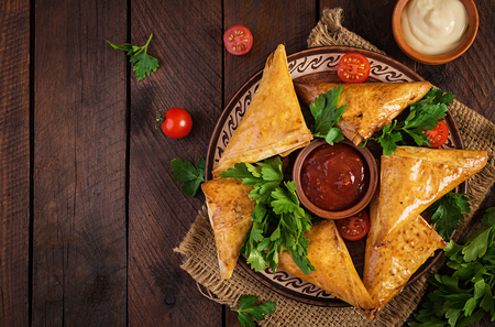 Asian food. Samsa (samosas) with chicken fillet and cheese on wooden background. Top viewの写真素材