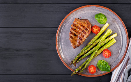 Barbecue grilled beef steak meat with asparagus and tomato. Top viewの写真素材