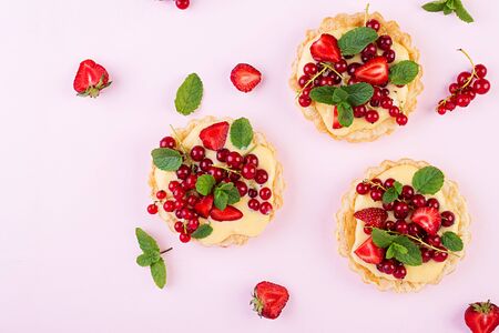 Tarts with strawberries, currant and whipped cream decorated with mint leaves. Top viewの写真素材