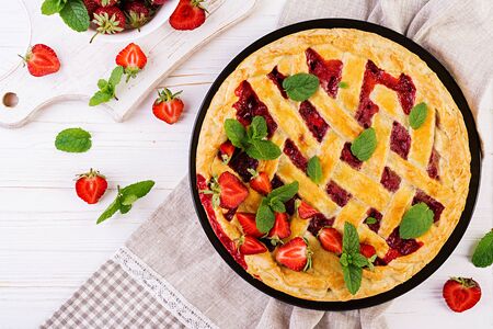 American strawberry pie tart cake sweet baked pastry food on white wooden table. Top viewの写真素材