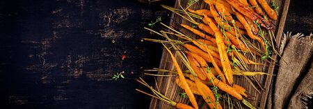 Baked organic carrots with thyme, honey and lemon. Organic vegan food. Banner. Top viewの素材 [FY310126784250]