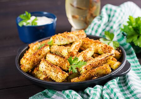 Baked zucchini sticks with cheese and bread crumbs. Vegan food. Vegetarian cuisine.の写真素材