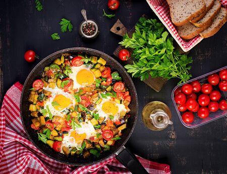 Late breakfast - fried eggs with vegetables. Shakshuka. Arabic cuisine. Kosher food. Top viewの写真素材