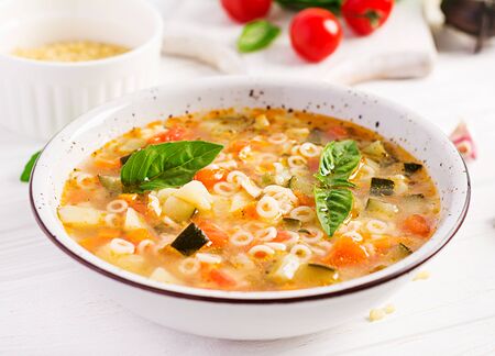 Minestrone, italian vegetable soup with pasta on white table. Vegan soup.の写真素材