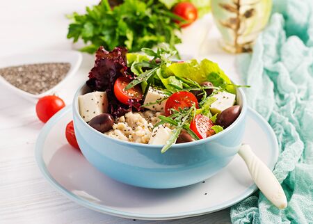 Vegan salad. Breakfast bowl with oatmeal, tomatoes, cheese, lettuce,  and olives. Healthy food. Vegetarian buddha bowl.の写真素材