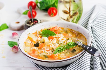 Minestrone, italian vegetable soup with pasta on white table. Vegan soup.の写真素材