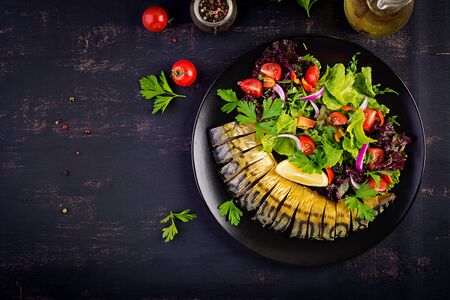 Smoked mackerel and fresh salad on dark background. Top viewの写真素材