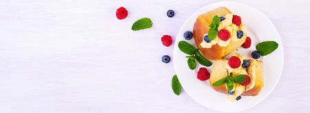 Rum baba decorated with whipped cream and fresh raspberry, blueberry. Savarin with rum, cream and...