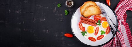 English breakfast - fried egg,  tomatoes, sausage,  and toasts. Banner. Top view, overheadの写真素材
