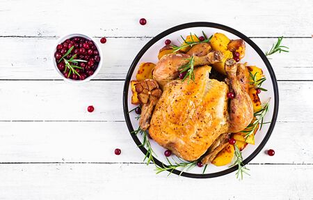 Roasted turkey garnished with cranberries on a rustic style table decorated  autumn leaf. Thanksgiving Day. Baked chicken. Top viewの写真素材