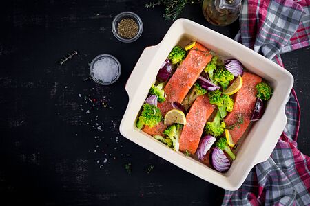 Salmon, broccoli and red onion slices are prepared in a baking dish. Top view, overheadの写真素材
