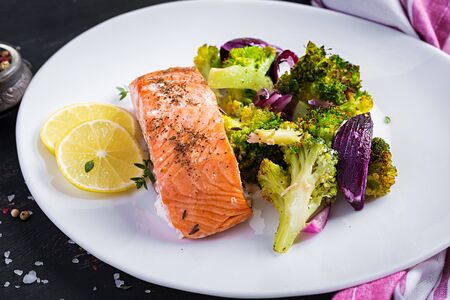 Baked salmon fillet with broccoli, red onion and lemon.の写真素材