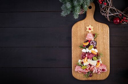 Antipasto platter with ham, prosciutto, salami, cheese and olives on a wooden background.  Christmas table. Top view, overheadの写真素材